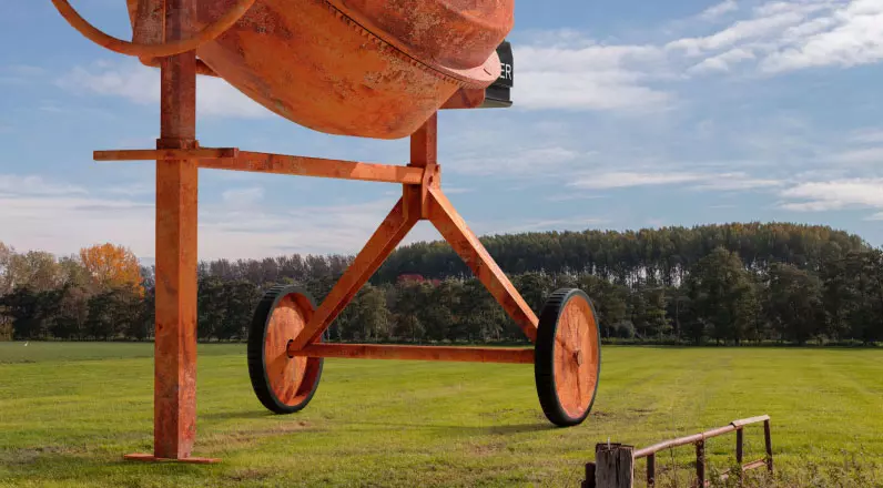 alt="Construction mixer on a field."
