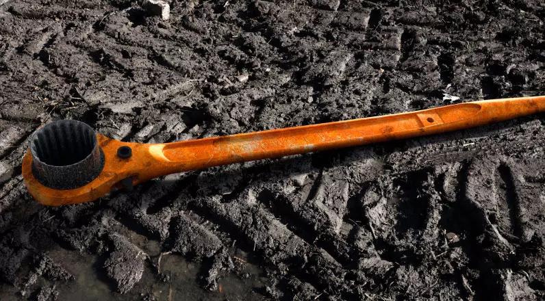 alt="Orange Scaffolding rattle on the muddy ground."