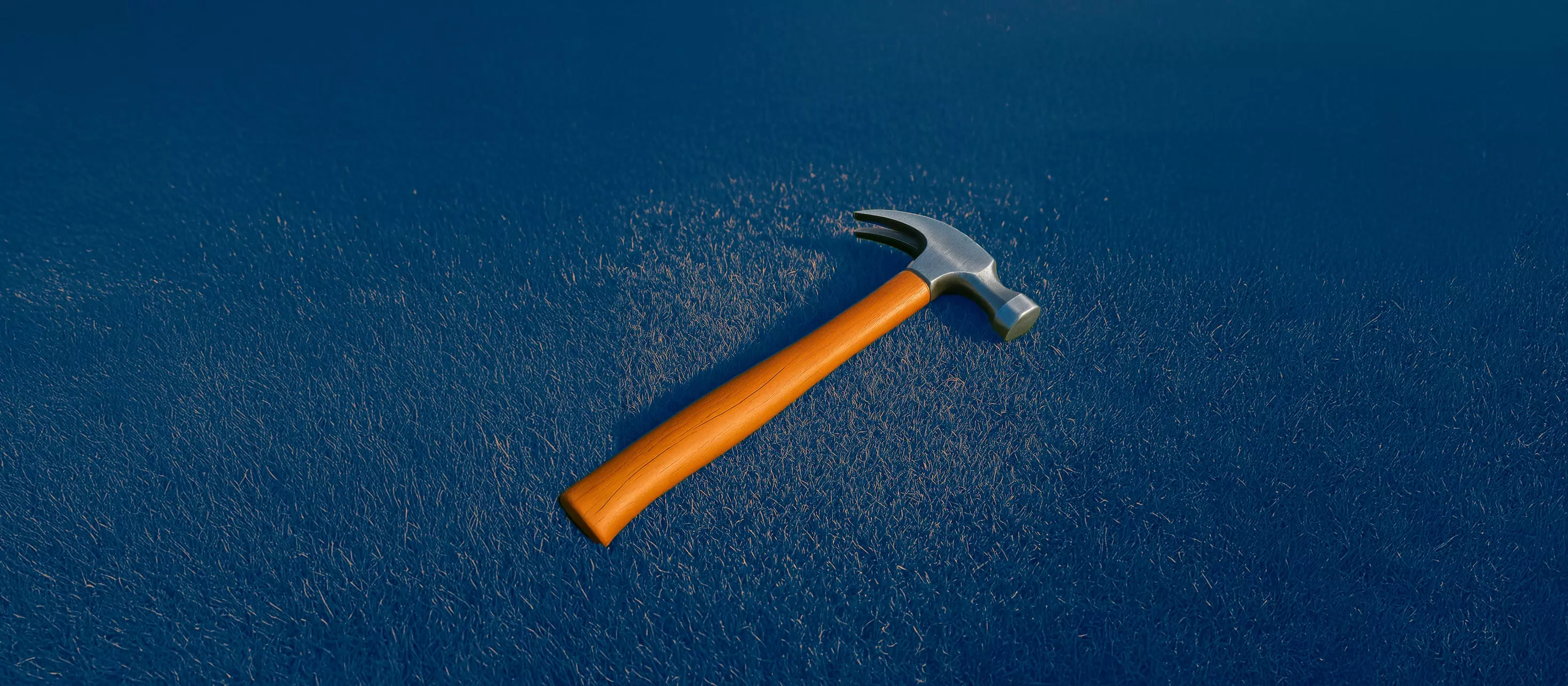 Orange claw hammer on the grass.